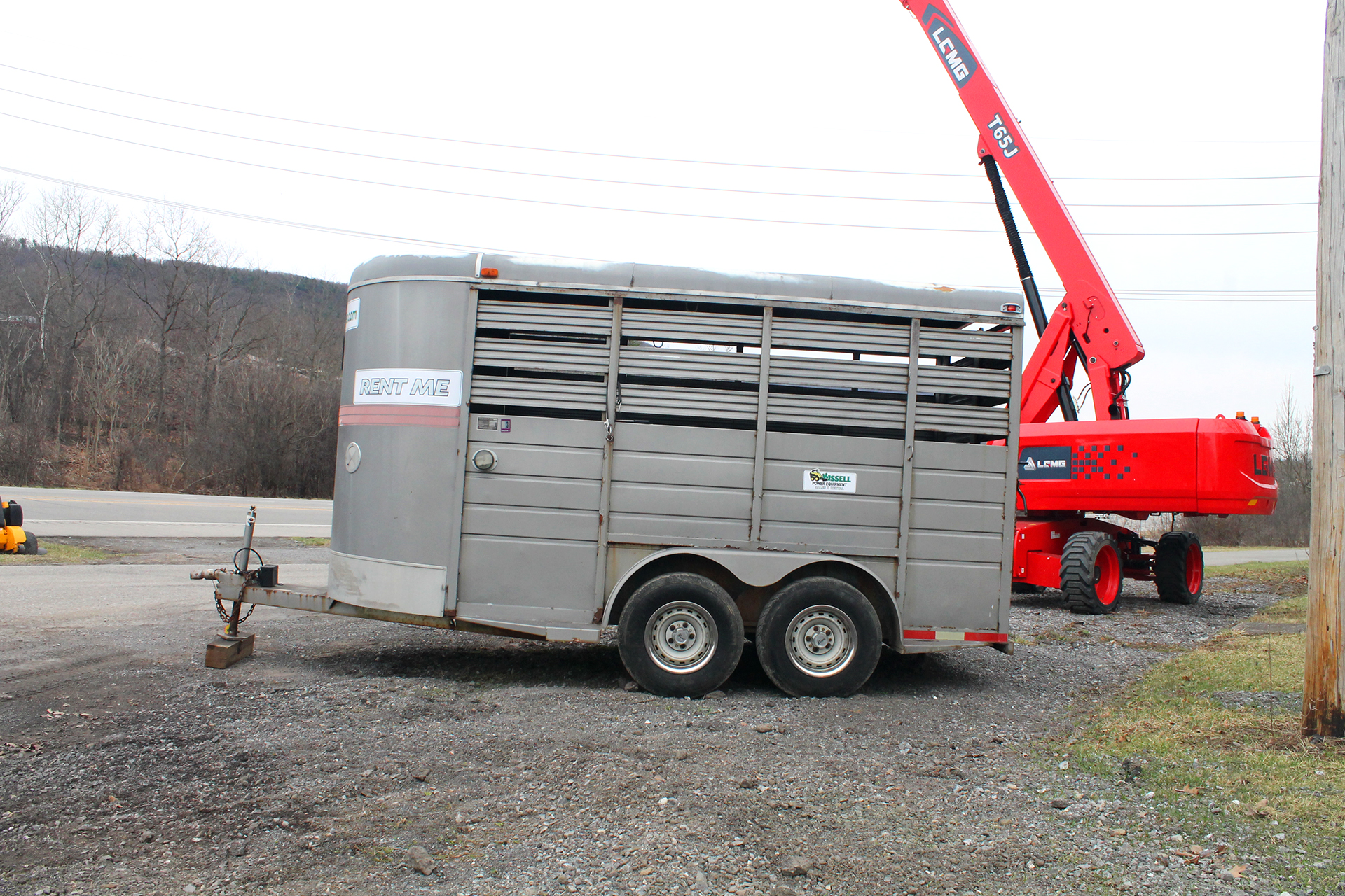 A grey, towable horse trailer that's able to transport a horse or other livestock